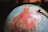 A globe is prominently featured, showcasing North America in detail. The geographic regions are marked in vibrant colors, with states and provinces clearly labeled. There's a metallic meridian ring with a pivot mechanism holding the globe.