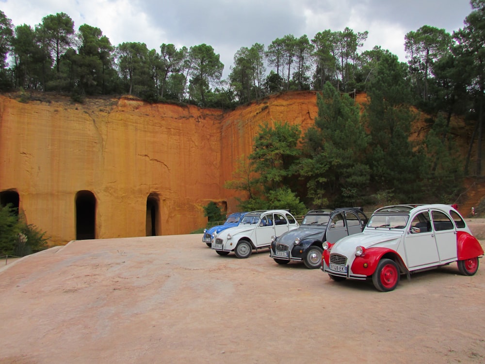 white and red cars parked beside brown concrete wall