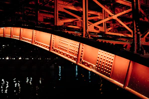 Night view of a brightly lit metal bridge showcasing intricate structural design
