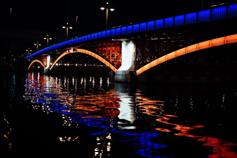 blue bridge over water during night time