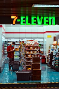 man in red t-shirt standing in front of food stall