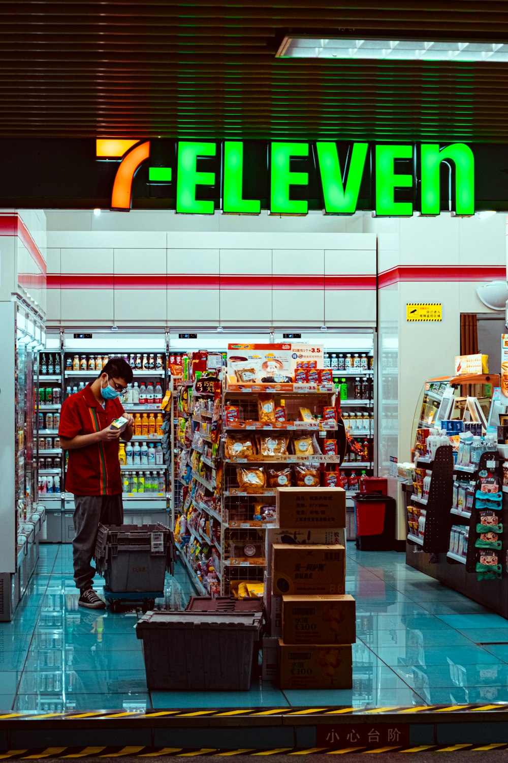 man in red t-shirt standing in front of food stall