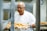 man in white crew neck t-shirt holding tray of orange fruits