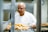 man in white crew neck t-shirt holding tray of orange fruits