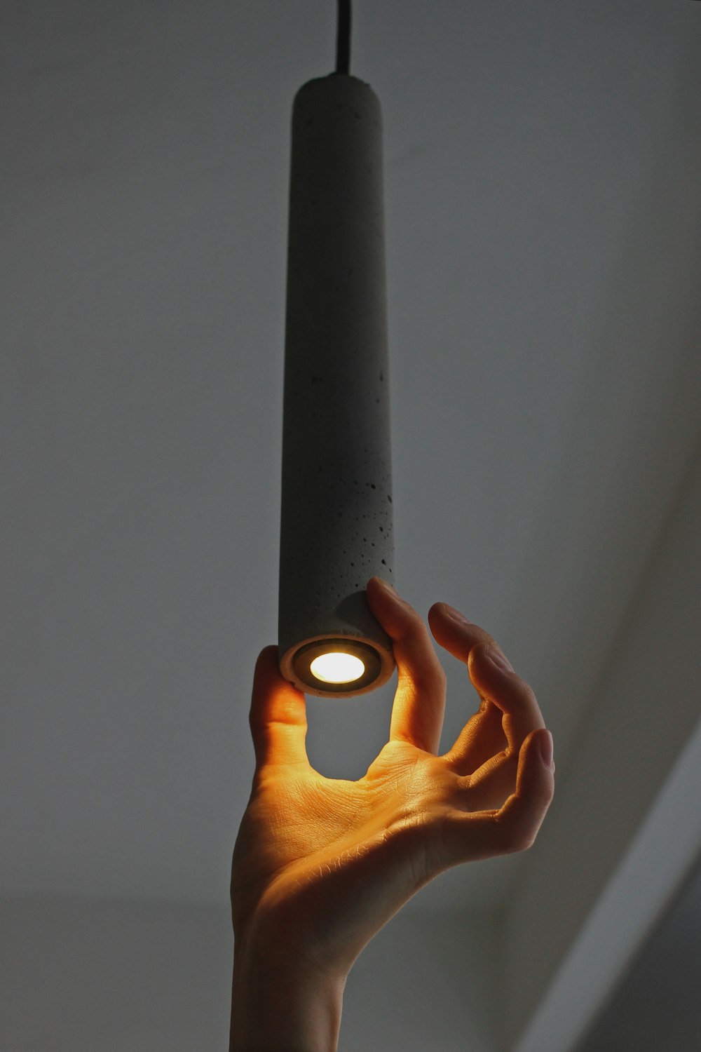 person holding black metal tube