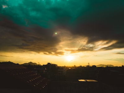 city skyline under blue and white cloudy sky during sunset emerald green teams background