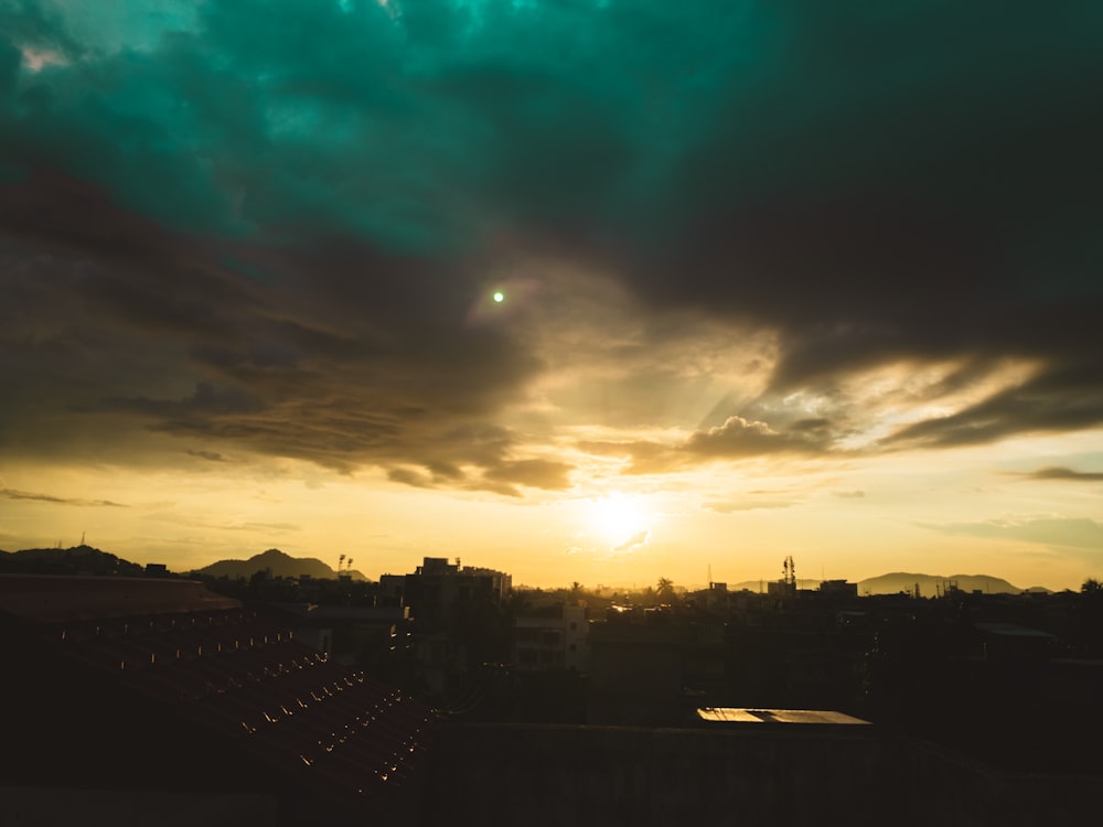 Horizonte de la ciudad bajo cielo nublado azul y blanco durante la puesta del sol