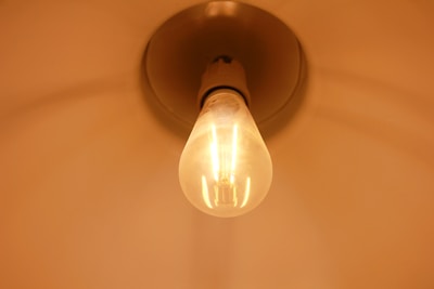 Close-up of a sleek 9W LED bulb glowing warmly against a clean white background.