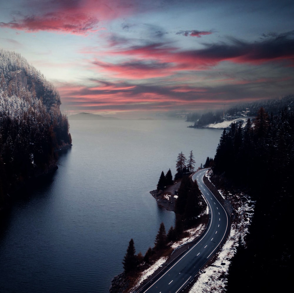 an aerial view of a road near a body of water