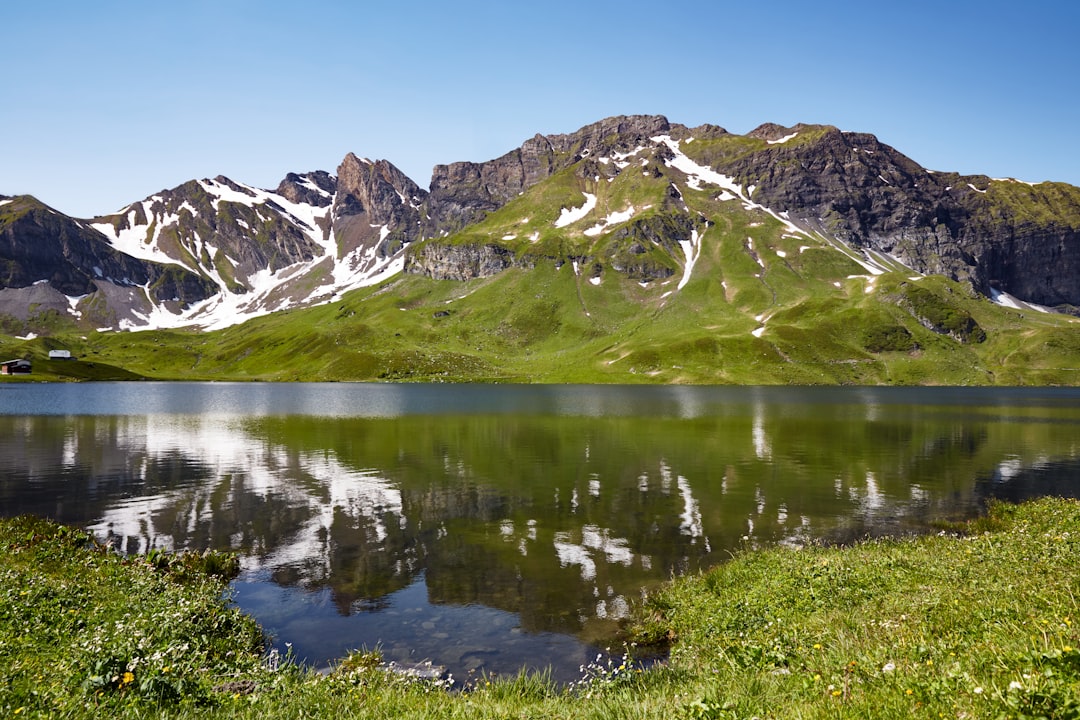 snow covered mountains near lake during daytime