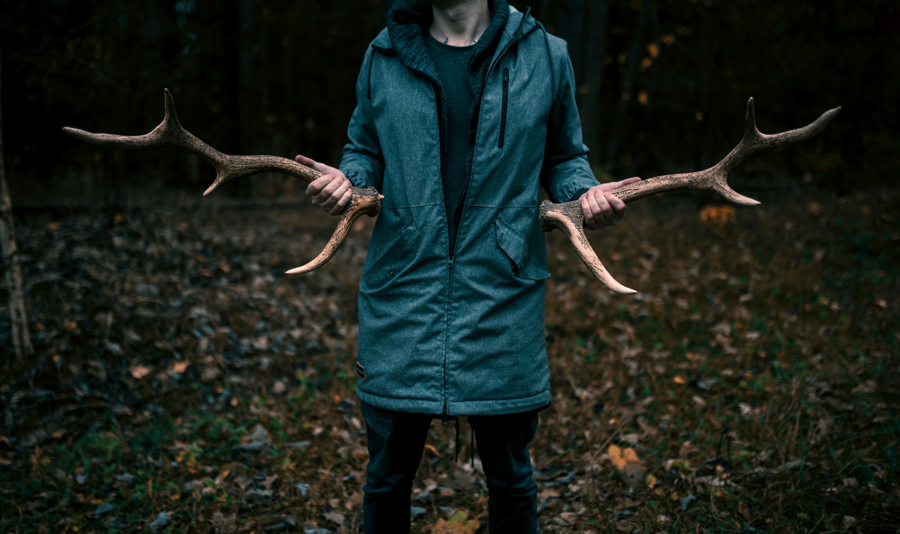 man-in-blue-zip-up-hoodie-standing-on-dried-leaves