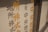 Vertical metal blinds with Japanese characters in orange and black are present on a window.
