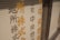 Vertical metal blinds with Japanese characters in orange and black are present on a window.