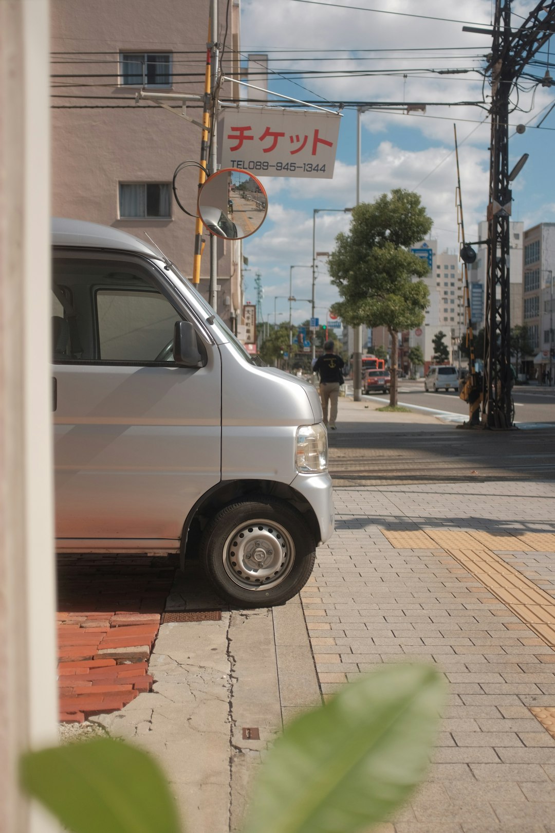 white van parked on sidewalk during daytime