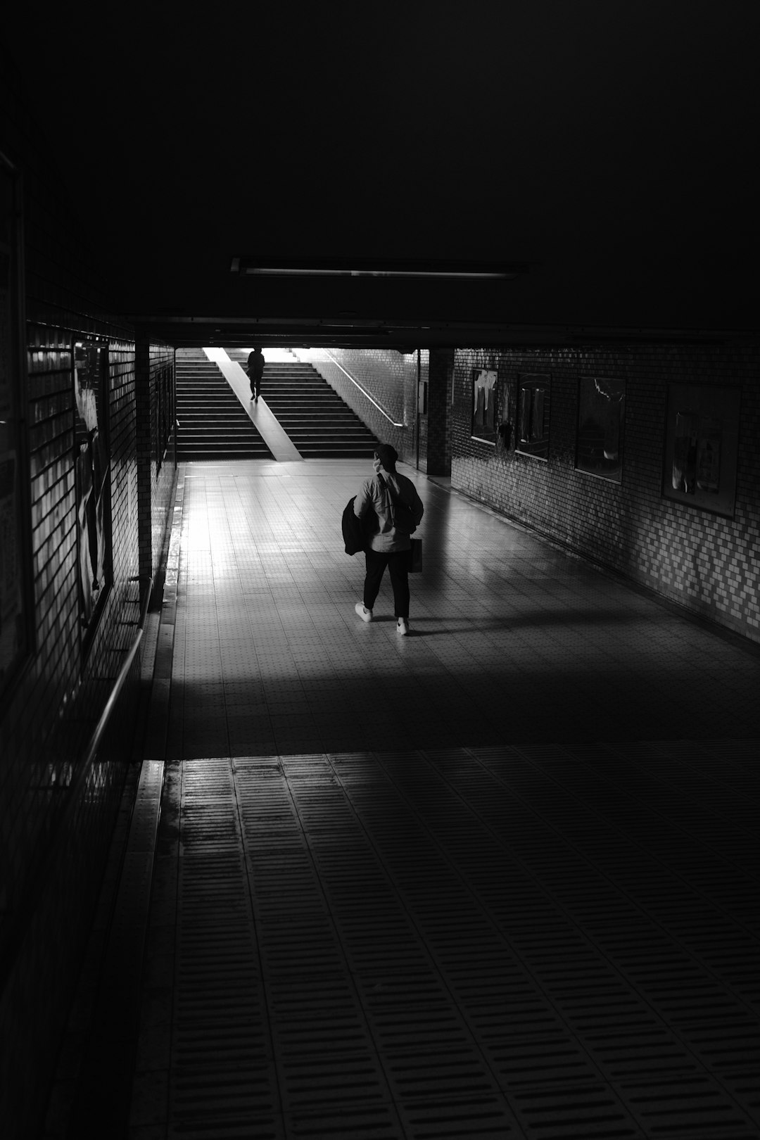 grayscale photo of 2 women walking on hallway