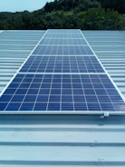 Solar panels installed on a sunny rooftop with green surroundings