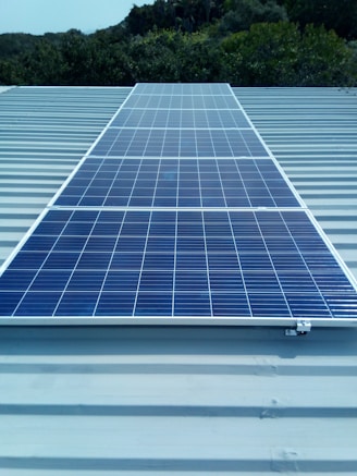 A sleek solar panel installed on a sunny rooftop with a clear blue sky background