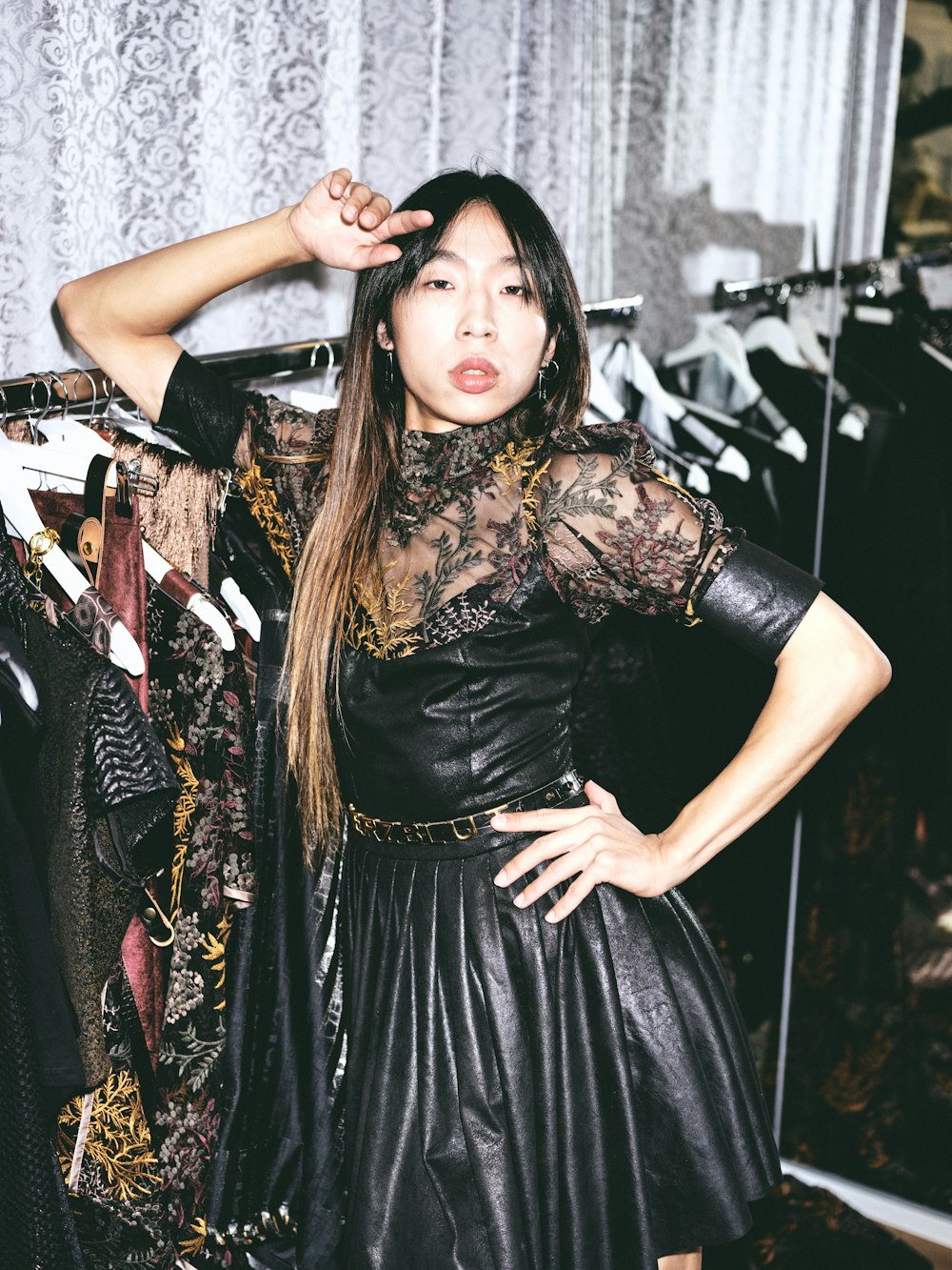 woman in black dress standing near clothes rack