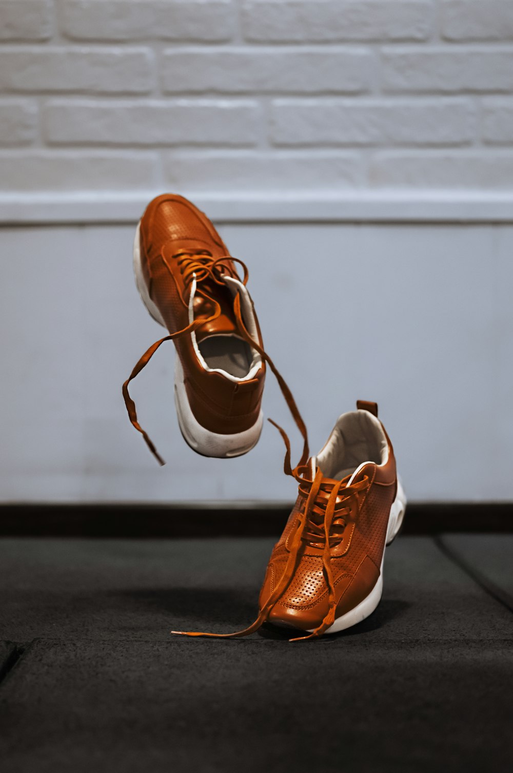 A pair of brown shoes hanging off the side of a wall photo – Free Fashion  Image on Unsplash