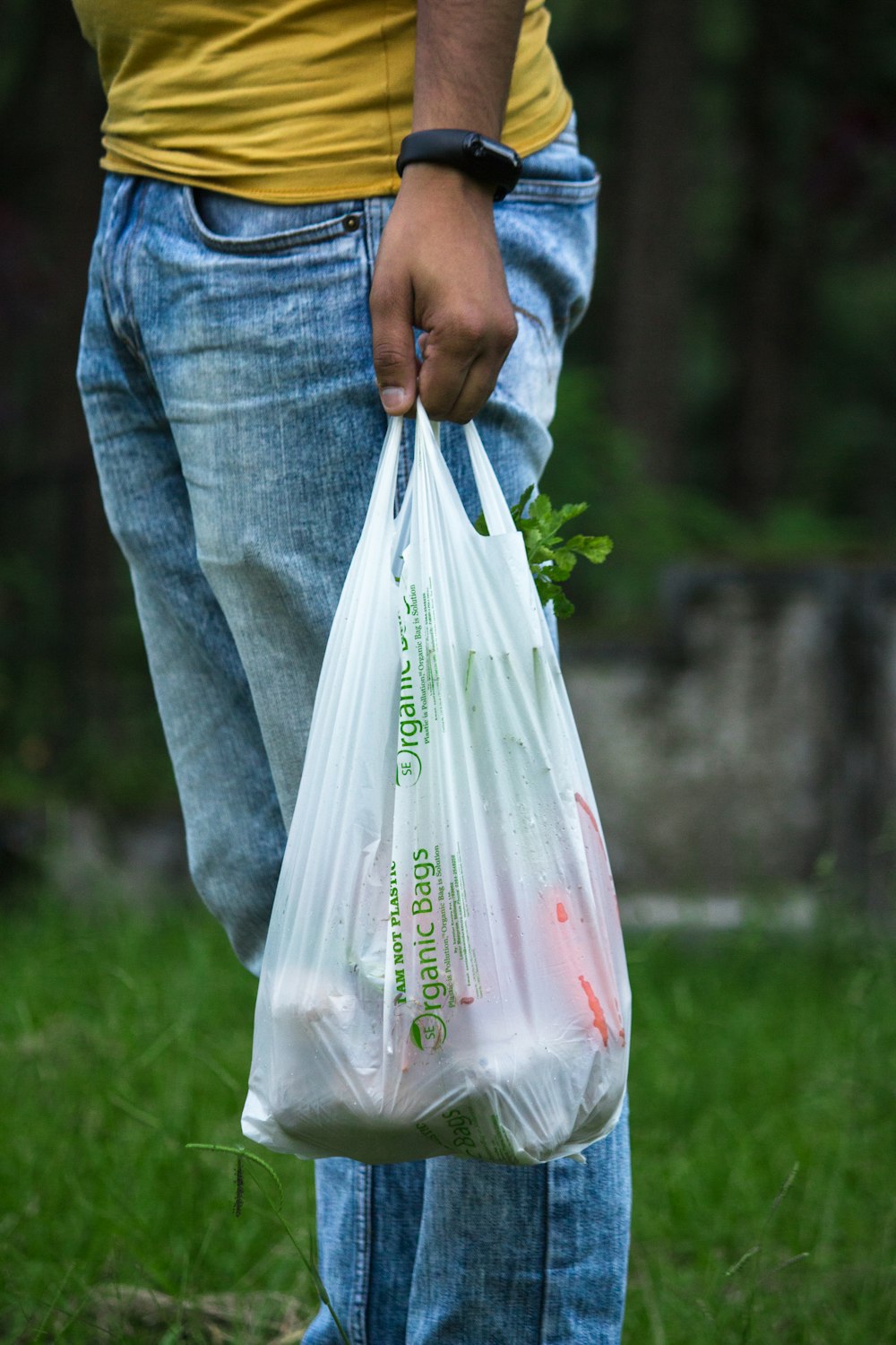 persona sosteniendo una bolsa de plástico blanca