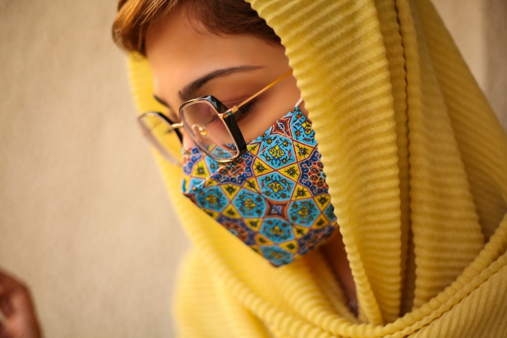 woman in yellow sweater wearing black framed eyeglasses