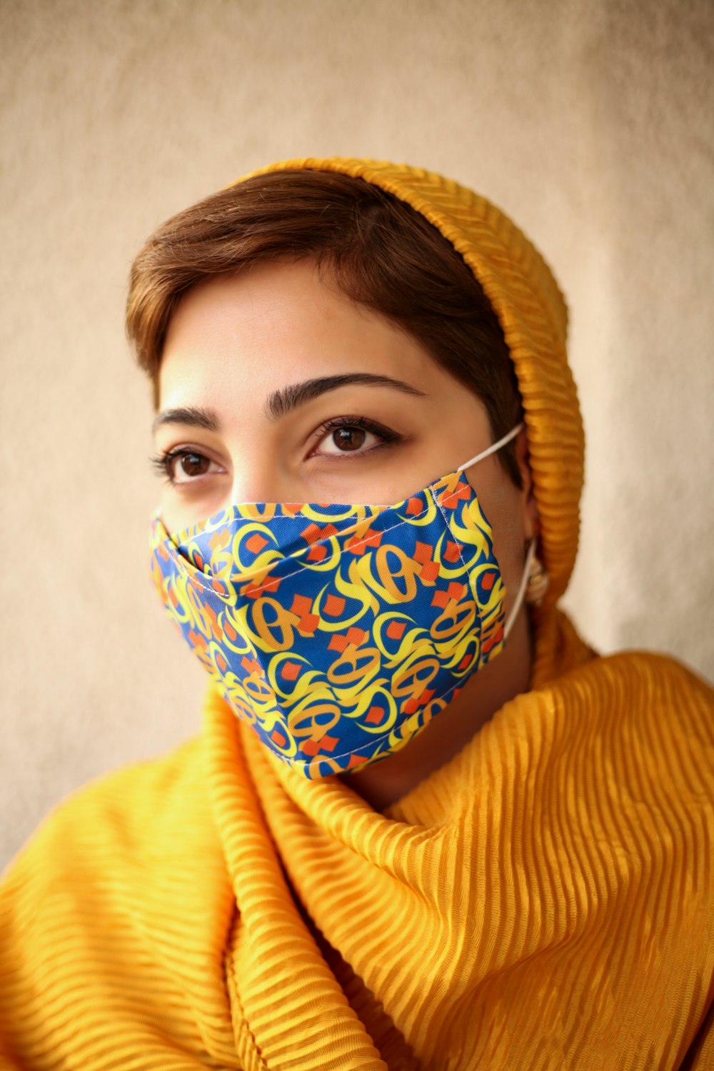 woman in yellow knit sweater wearing blue and white mask