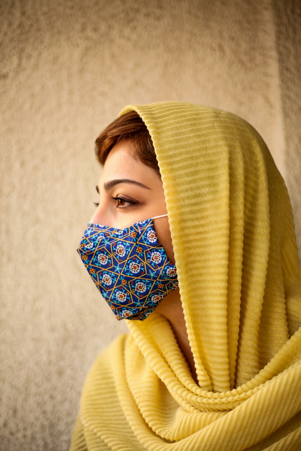Mujer con hiyab amarillo cubriendo su rostro con tela amarilla