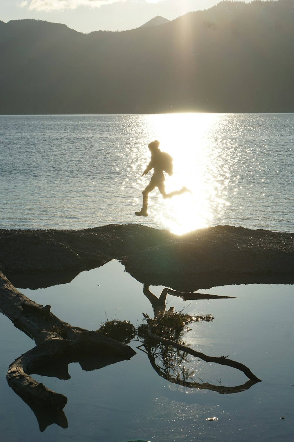 person standing on rock near body of water during daytime