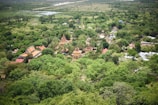A panoramic view of a lush green landscape with traditional Manipur architecture.