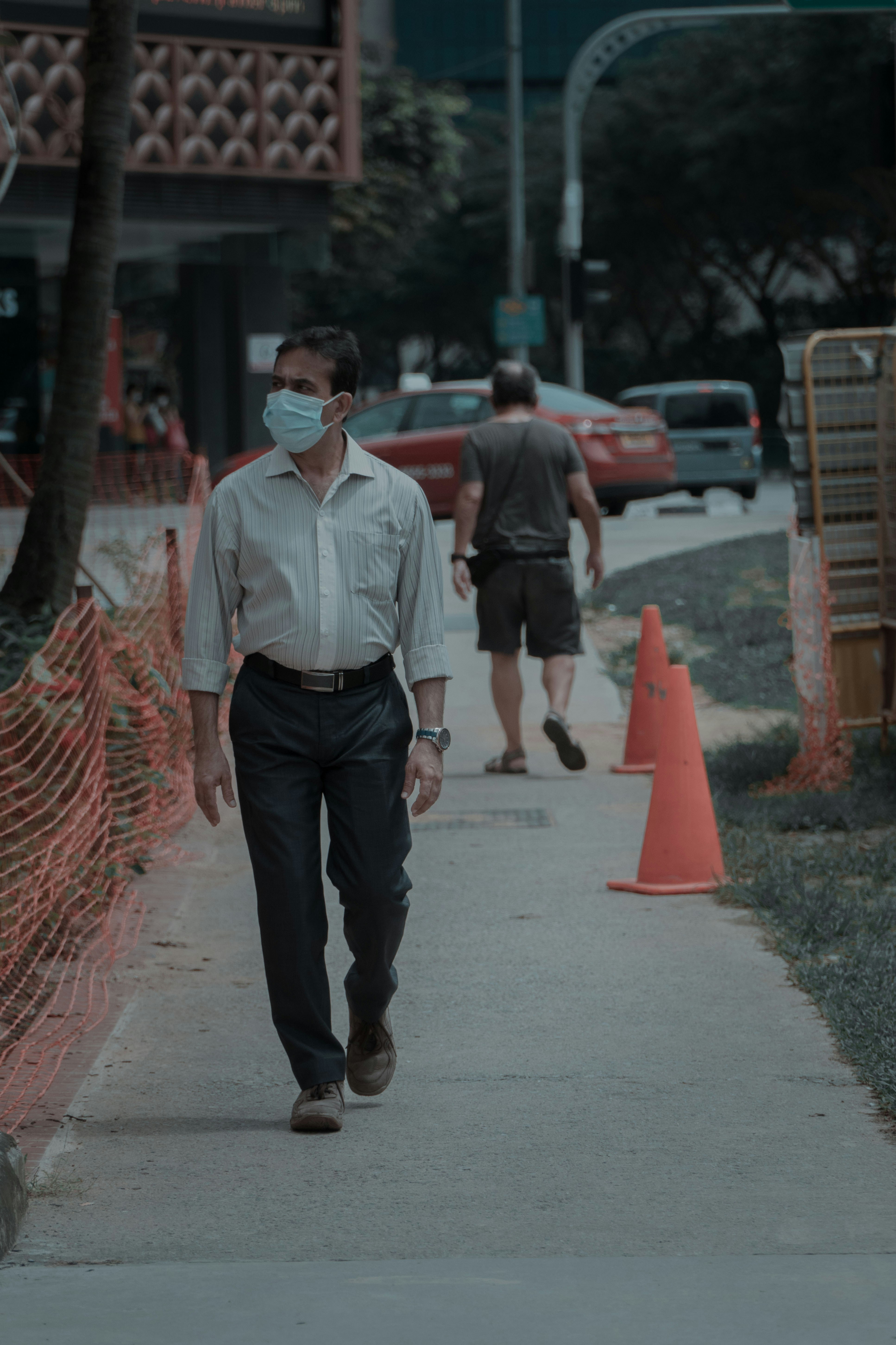 man in white dress shirt and black pants standing on road during daytime