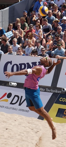 Crowd cheering enthusiastically at an outdoor volleyball stadium under bright New Zealand skies.