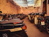 Organized rows of motorcycles inside the warehouse with clear signage and lighting.