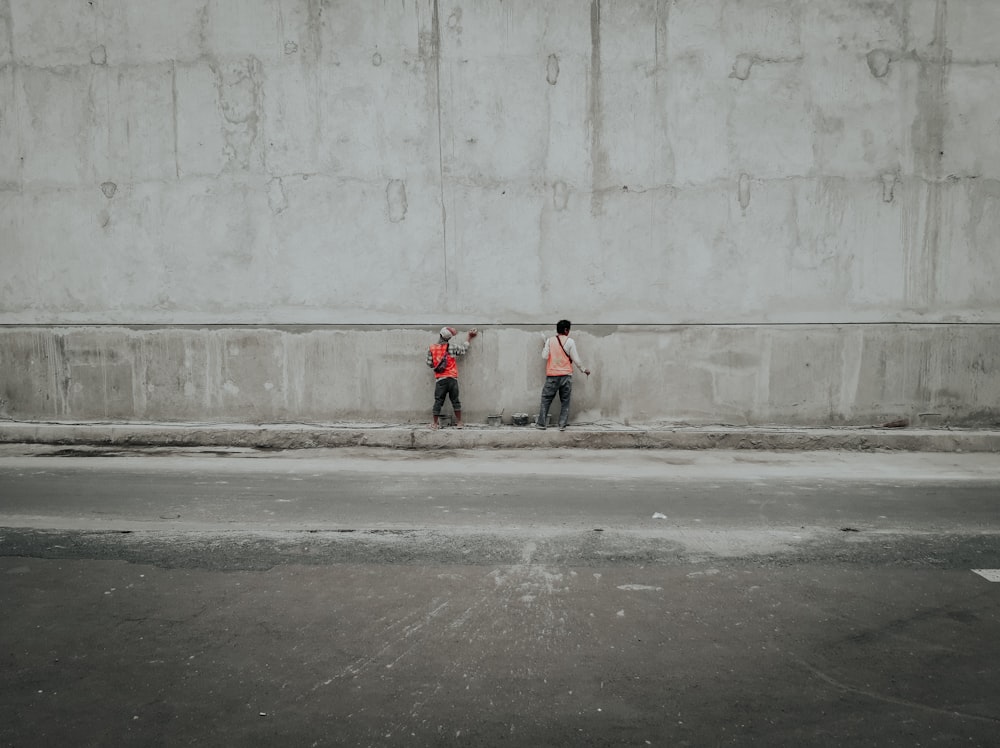 person in red jacket walking on sidewalk during daytime