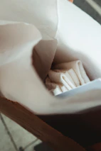 Hands inspecting a freshly printed paper bag in a bright, modern workspace with natural light.