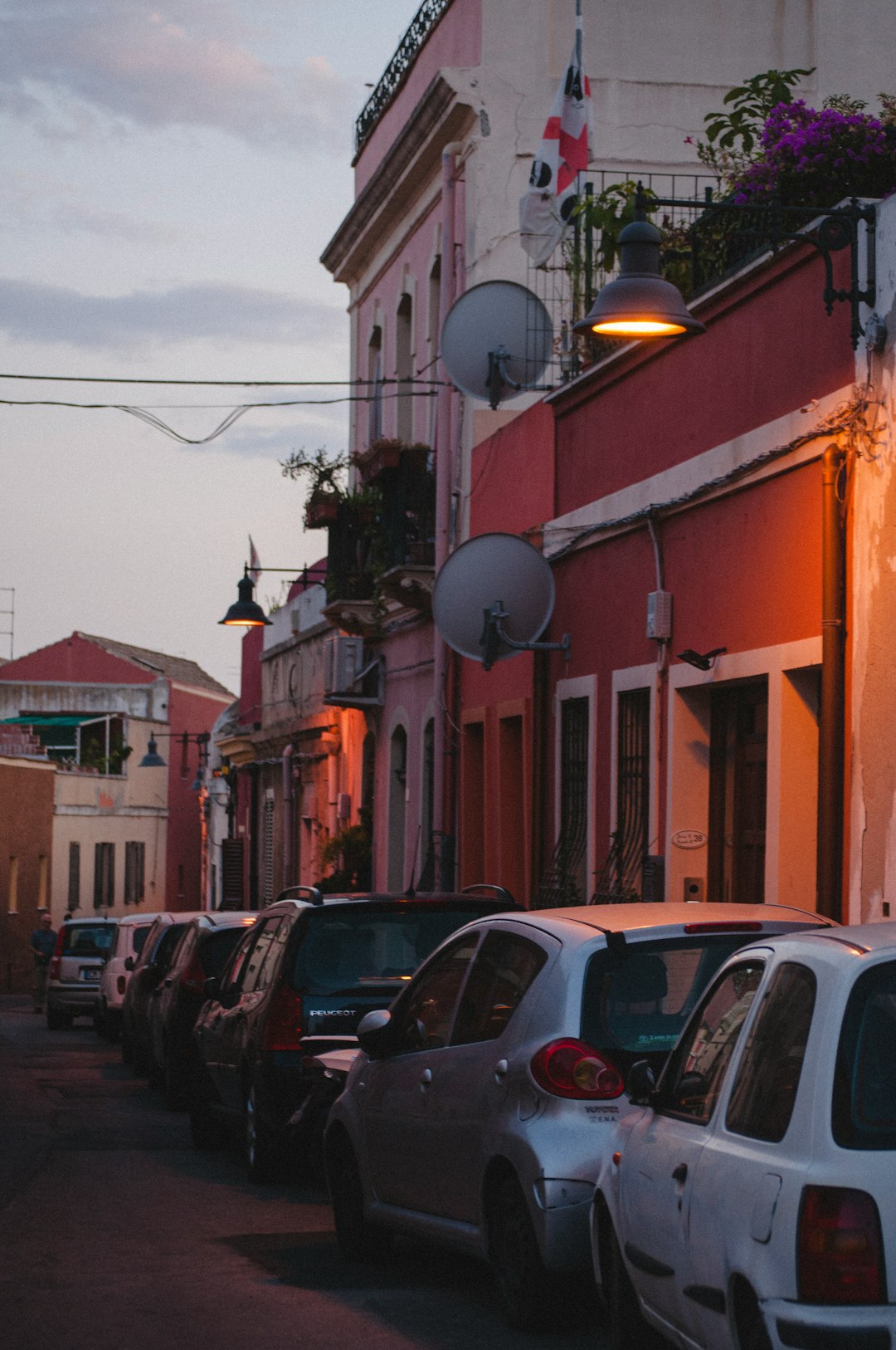 cars parked beside brown concrete building during daytime