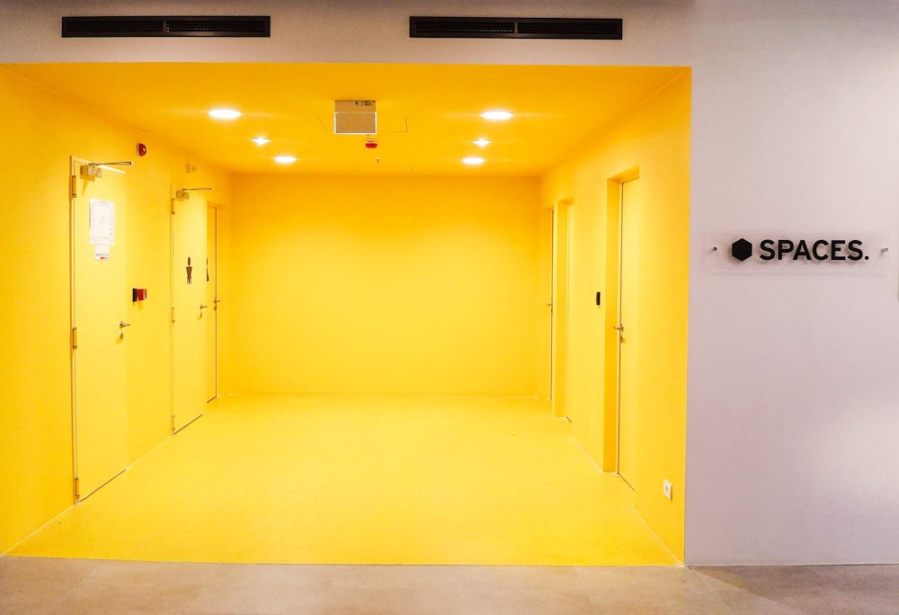 yellow wooden door on white painted wall