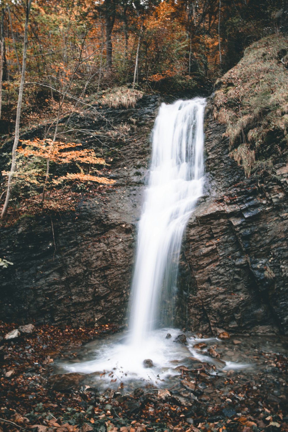 water falls on brown rocky mountain