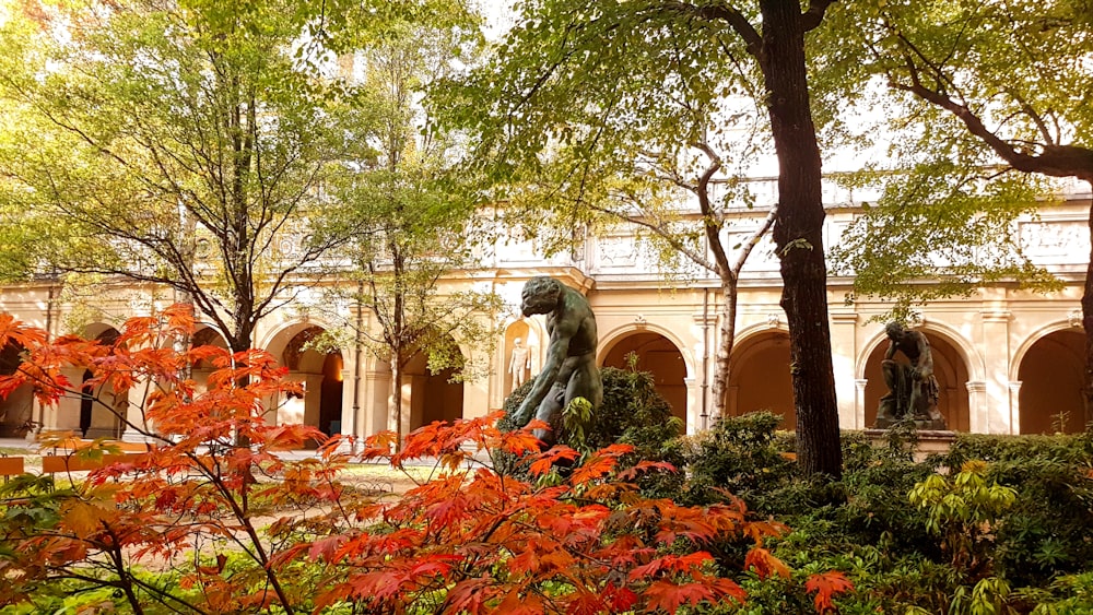 white concrete statue on orange and green leaves