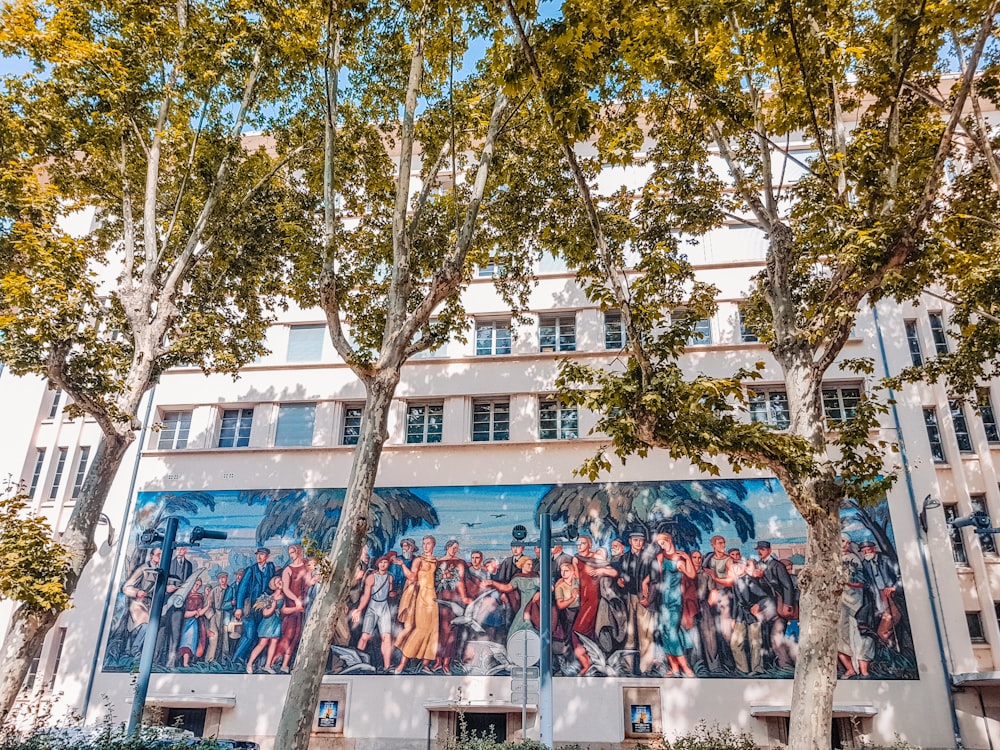 personnes debout près d’un bâtiment en béton bleu et blanc pendant la journée