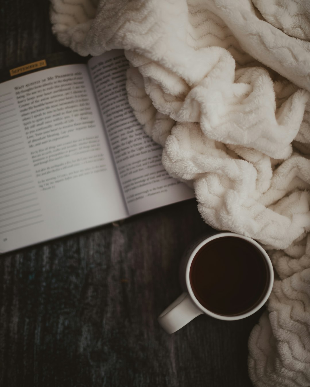 white ceramic mug beside white textile