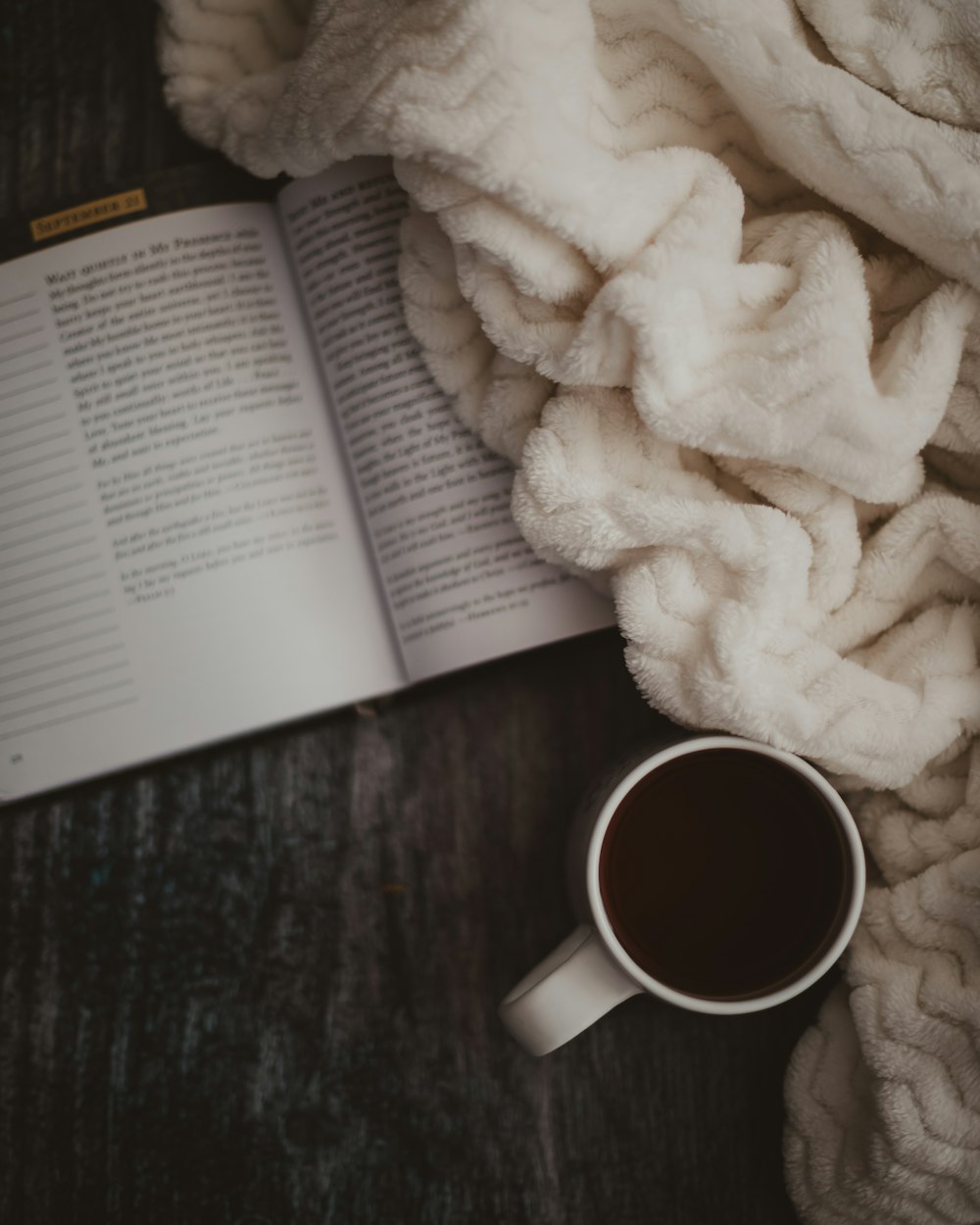 taza de cerámica blanca junto a textil blanco