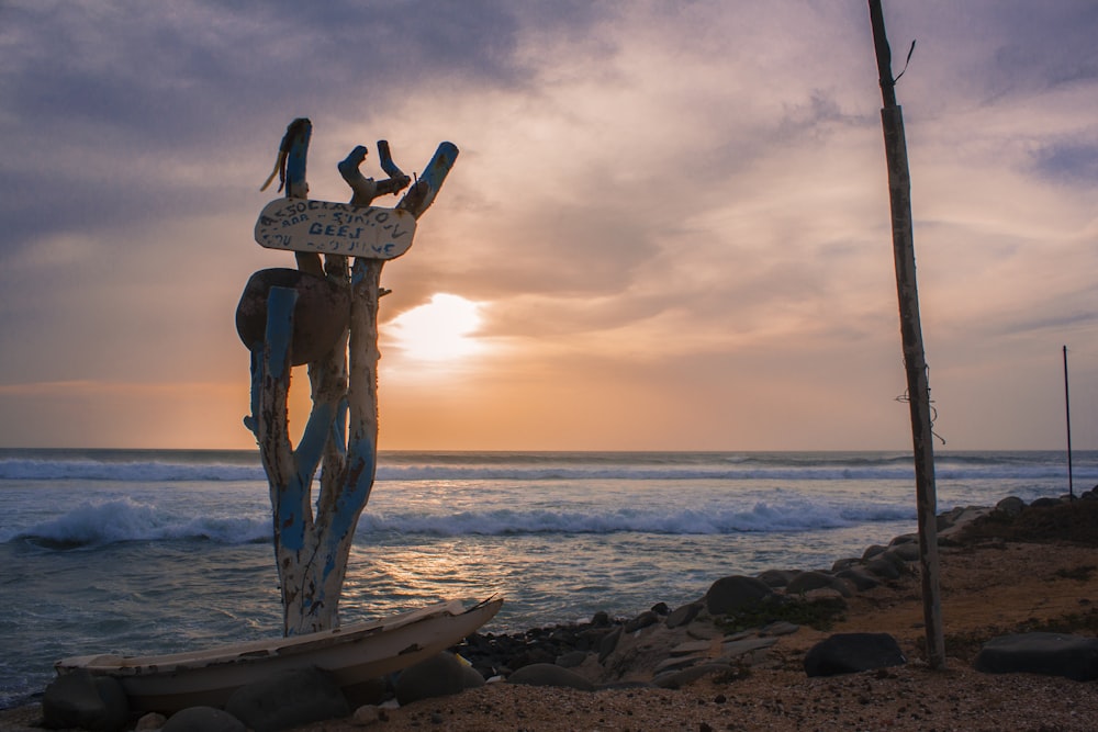 Mujer en bikini de lunares blanco y negro de pie sobre columpio de madera marrón en la playa durante