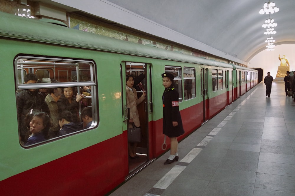 Personas en tren rojo y blanco durante el día