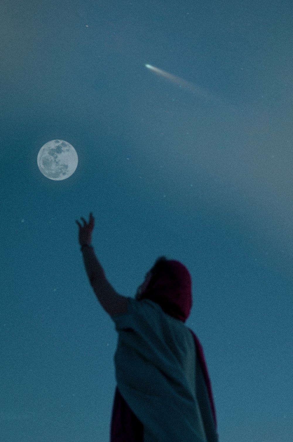 Person in rotem Kapuzenpullover schaut auf den Mond