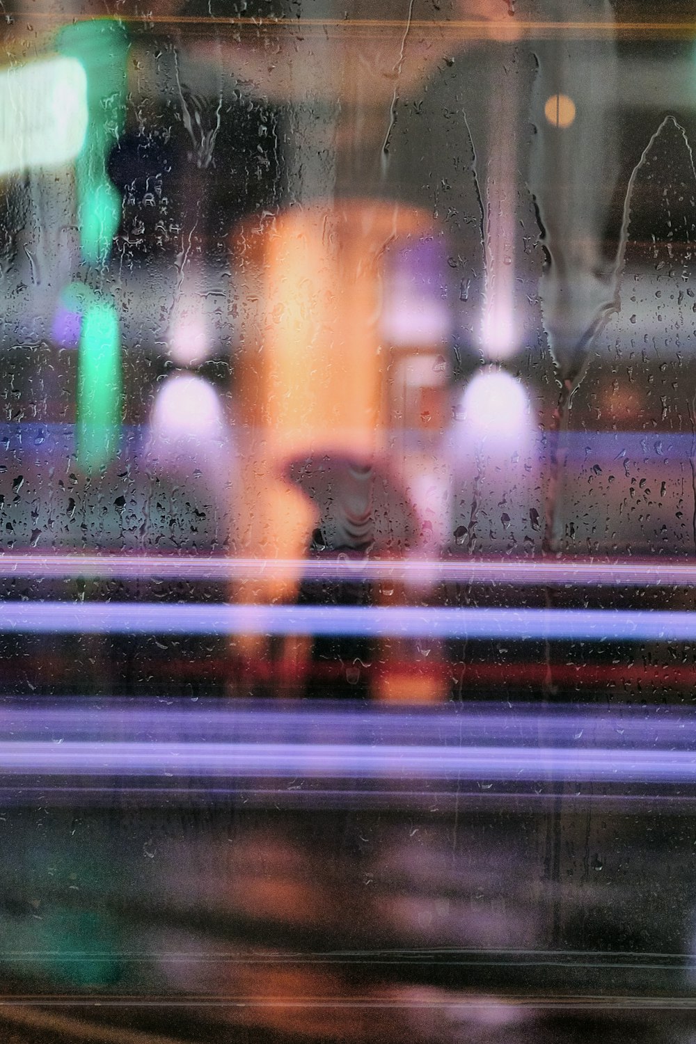 person in black jacket standing in front of glass window