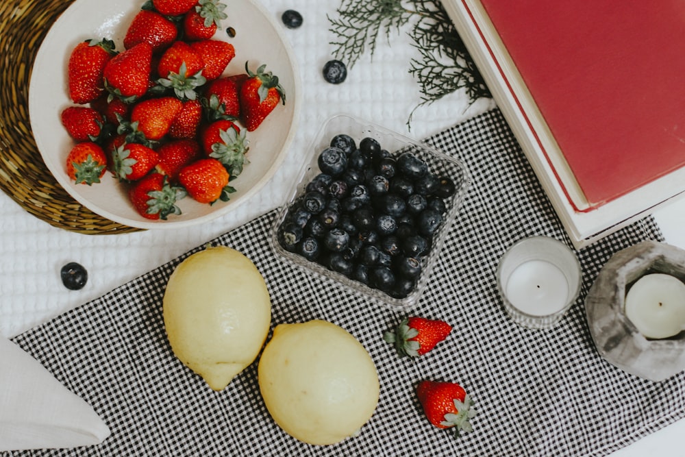 sliced strawberries and blue berries on white ceramic plate