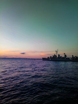A serene sunset over calm ocean waters, reflecting the quiet strength of a naval journey.