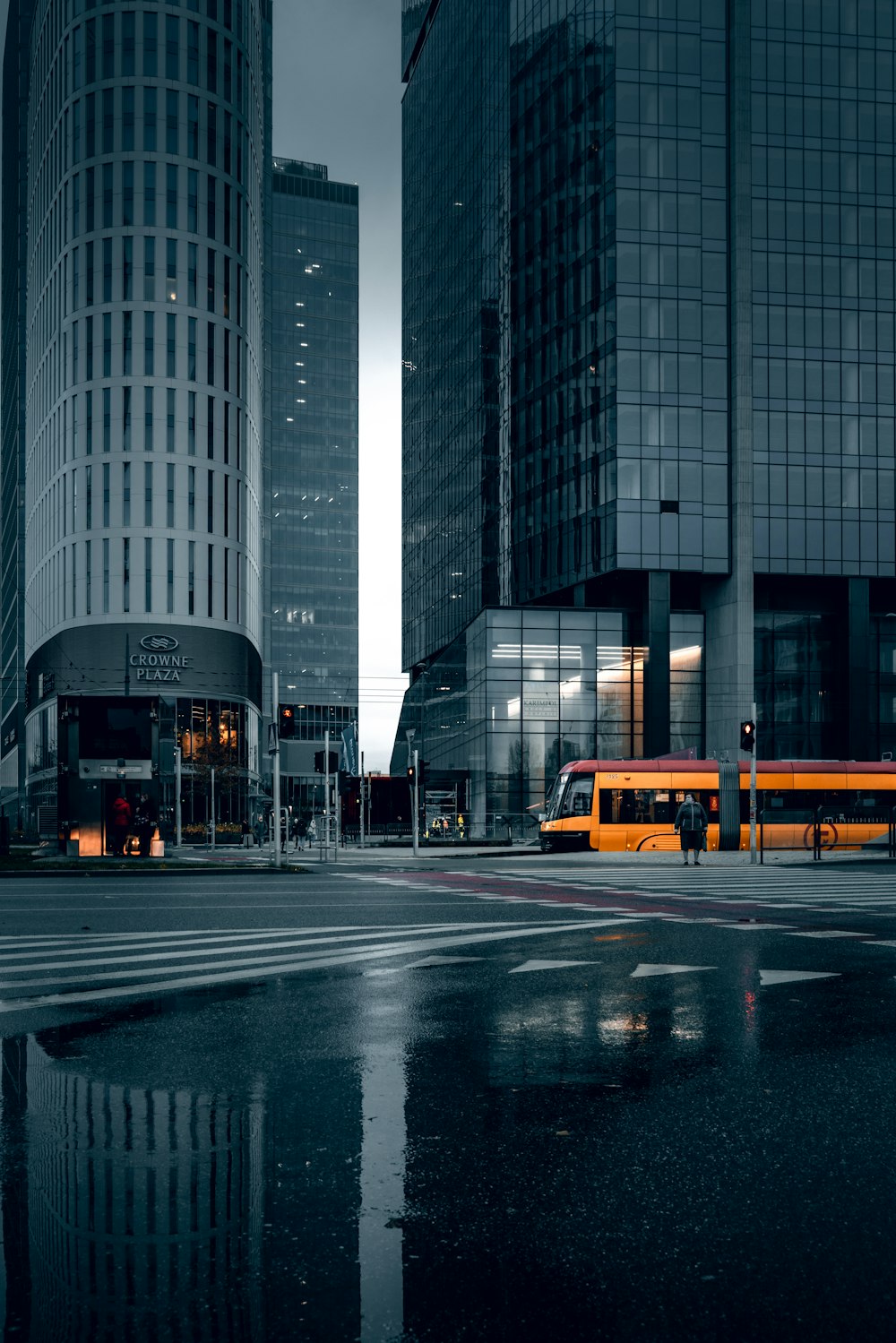 昼間の高層ビル近くの道路に黄色いバス