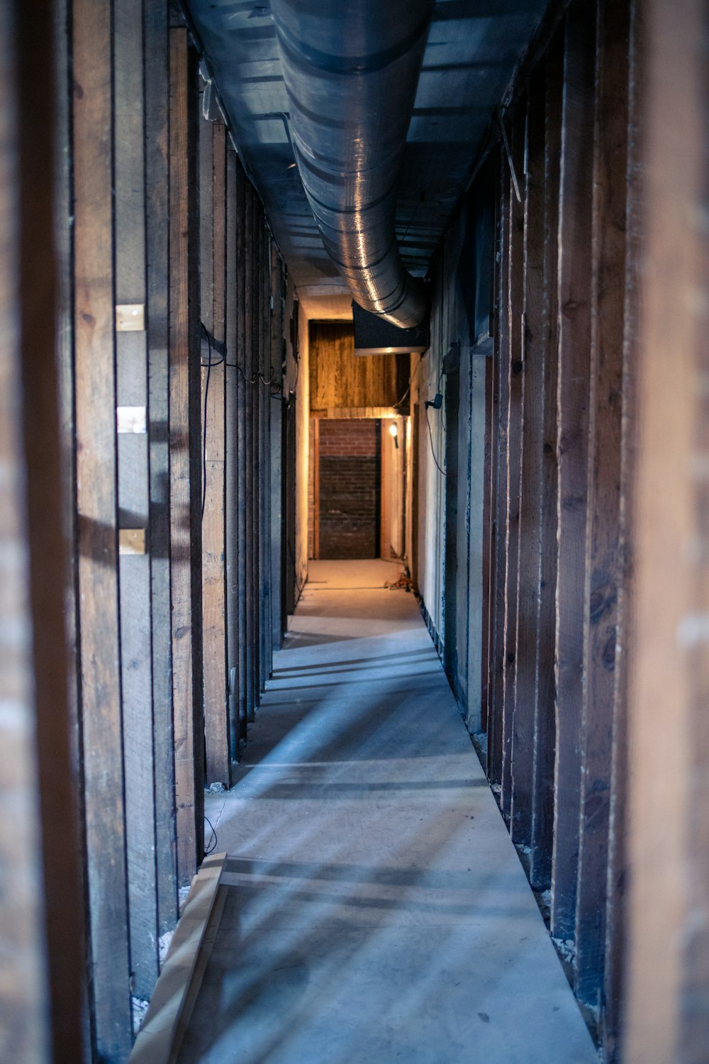 gray concrete hallway with brown wooden doors