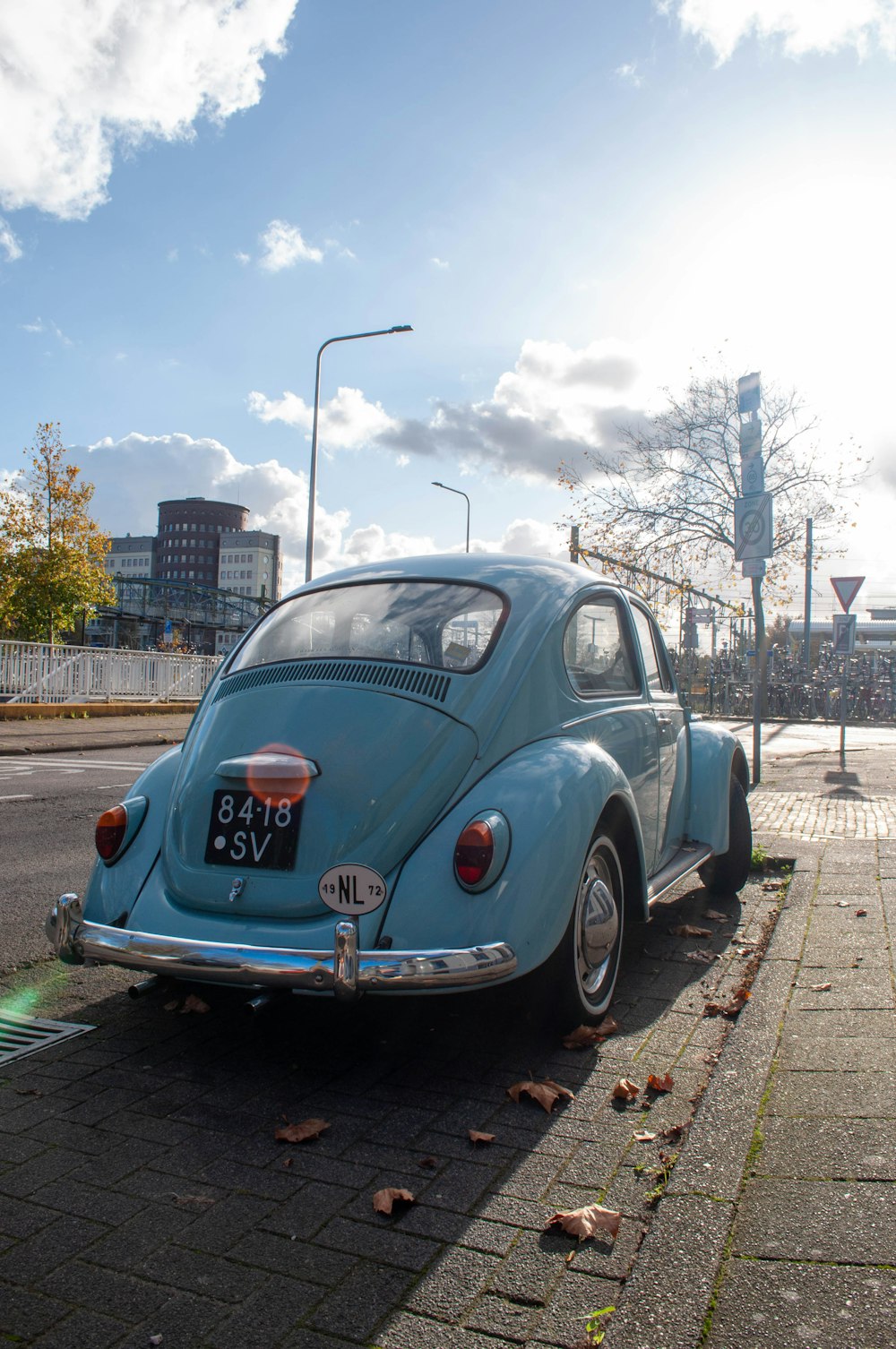 blue volkswagen beetle parked on roadside during daytime